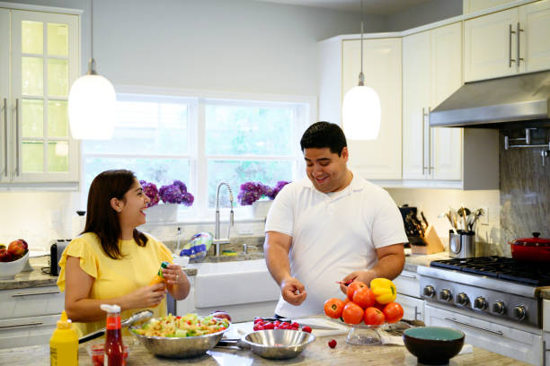 istock Laughing Hispanic husband and wife together in the kitchen 1210968542