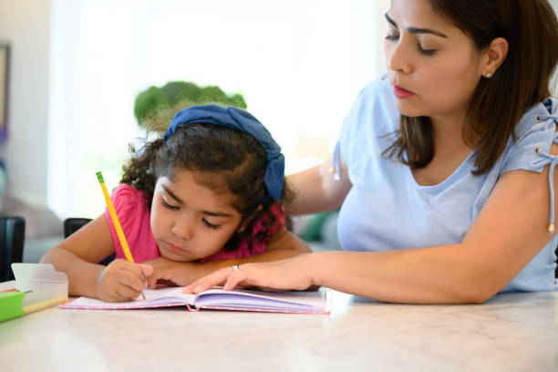 istock Hispanic mother and young daughter doing homework together 1210968550