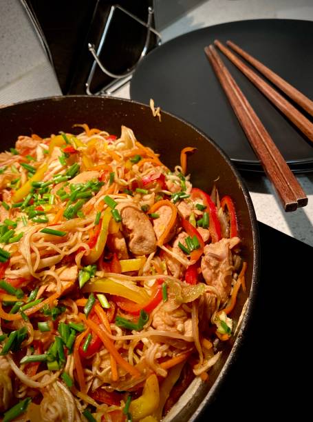 istock Udon noodles with chicken and vegetables in a wok 1210975548