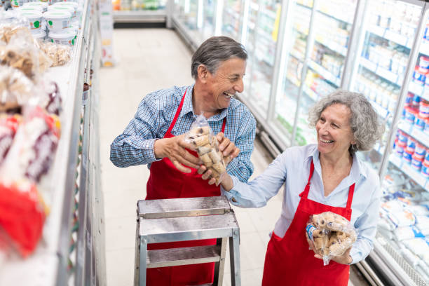 senioren arbeiten im supermarkt - regalauffüller stock-fotos und bilder