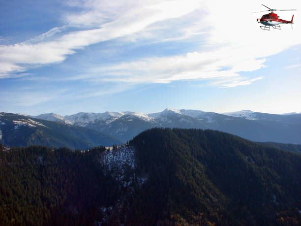 istock Red Helicopter flying above the mountain 1210976831