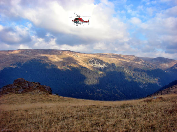 istock Red Helicopter flying above the mountain 1210976898