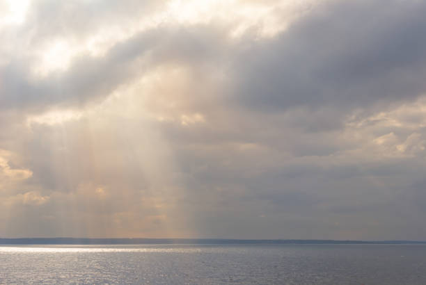 istock sun push through dense clouds above a sea bay 1210979664