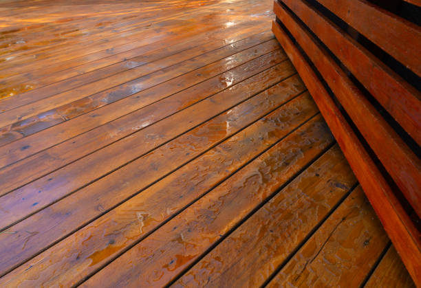 Backyard wooden deck floor boards with fresh brown stain, angled view