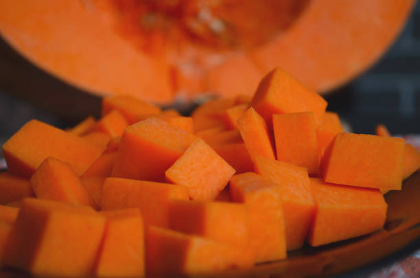 istock Fresh raw pumpkin on a diced board. Gray-orange background. Vegetarian cuisine. 1210984624