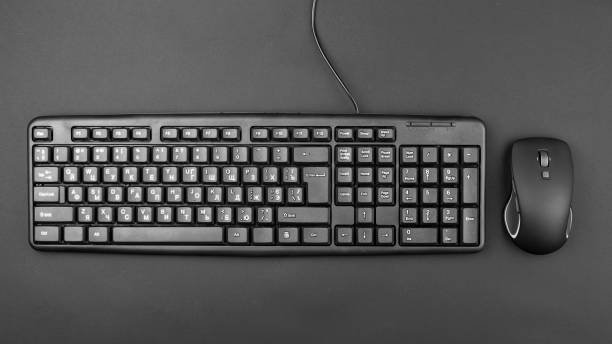 istock keyboard for computer with a wire on the table. nearby lies a wireless mouse. 1210985830