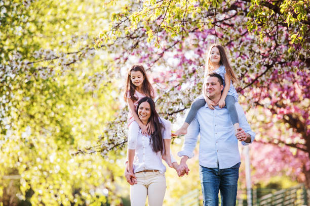 istock Young parents with small daugthers walking outside in spring nature. 1210986333