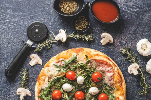istock Pizza with mozzarella, cherry tomato, rocket and mushrooms 1210987380