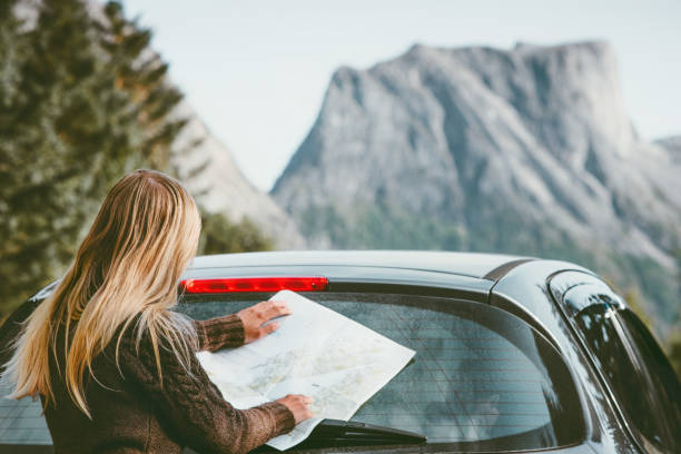 ノルウェートラベルライフスタイルコンセプトアドベンチャー週末の休暇屋外の山々の地図でレンタカーロードトリップで旅行する地図計画ルートを持つ女性 - car map car rental land vehicle ストックフォトと画像