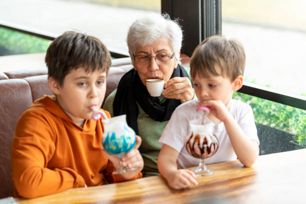 Grandmother drinks turkish coffee and grandson drinks milkshake in a cafe shop.