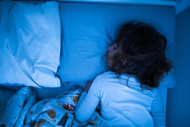 istock Small 11 year old girl sleeping in bed on a stomach. 1210993258