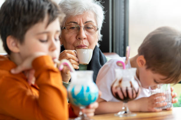 Grandmother drinks turkish coffee and grandson drinks milkshake in a cafe shop.
