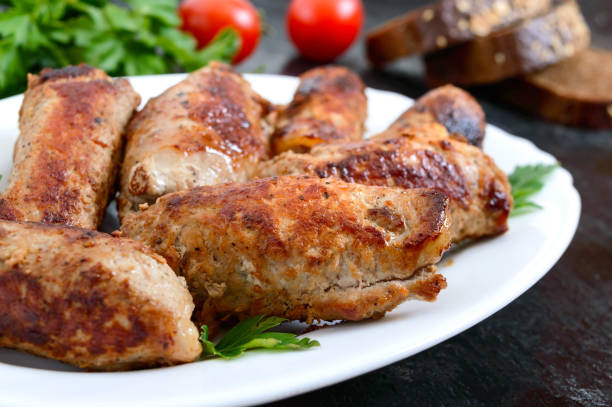 istock Tasty meat rolls with mushroomson a plate on a black background 1210993319