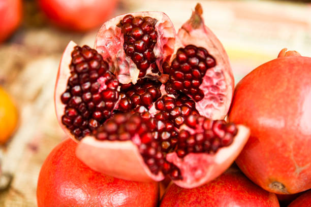 mostra di melograno aperta in un mercato - pomegranate fruit tropical fruit freshness foto e immagini stock