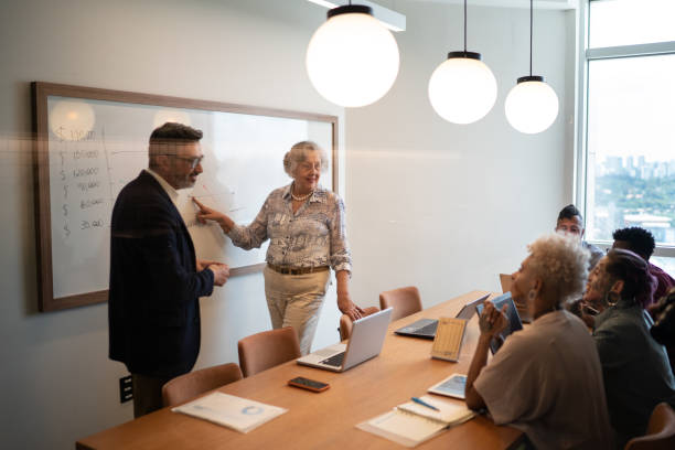 istock Business people watching a presentation at meeting room 1211000779