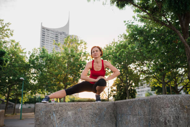 istock Young woman doing exercise outdoors in city at sunset, stretching. 1211001001