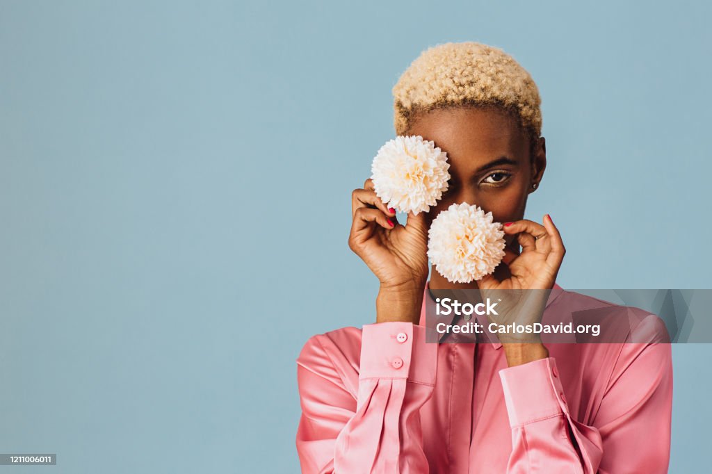 Portrait of a beautiful young woman holding two white pink flowers Women Stock Photo