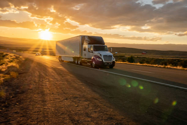 long haul semi truck speeding down a four lane highway to delivery heavy cargo - four lane highway stock-fotos und bilder