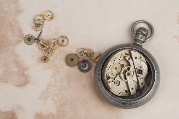 istock Time concept - broken vintage pocket watch on dirty paper background 1211009643