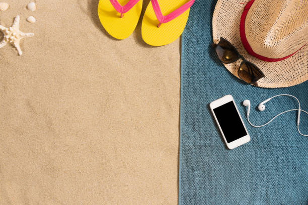 istock Summer vacation composition. Hat, smartphone and sunglasses on sand background. Harsh light with shadows. Summer background. Border composition made of towel 1211011184