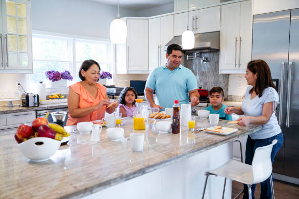 istock Hispanic family members enjoying breakfast in the kitchen 1211017200