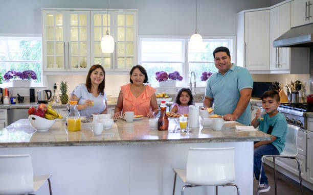 istock Smiling Hispanic family enjoying breakfast in the kitchen 1211017201