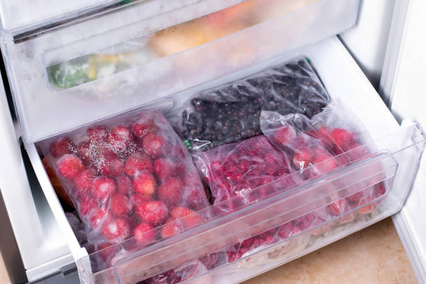 istock Plastic bags with different frozen berries in refrigerator 1211020489