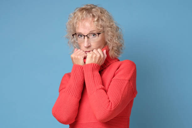 istock Elderly lady with a lively smile posing against a blue background 1211022741
