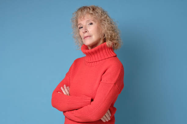 istock Elderly lady with a lively smile posing against a blue background 1211022789
