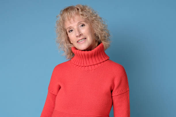 istock Elderly lady with a lively smile posing against a blue background 1211022810