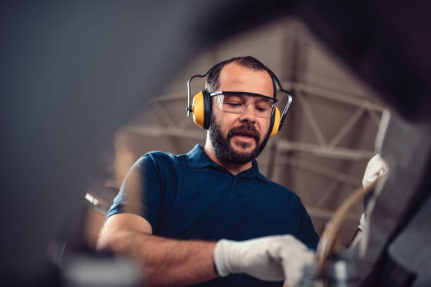 istock Factory worker operating band saw cutting machine 1211022884