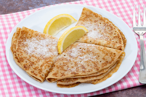 Hot sweet pancakes with lemon and sugar