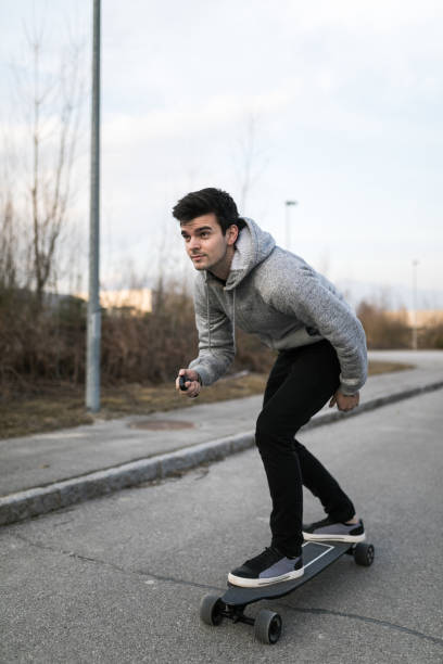 istock Man on a electric skateboard on an empty road 1211023832