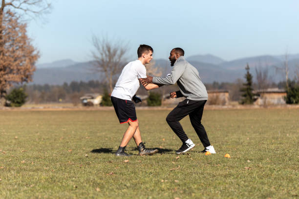 male athletes training american football outdoors - playing field effort outdoors human age imagens e fotografias de stock