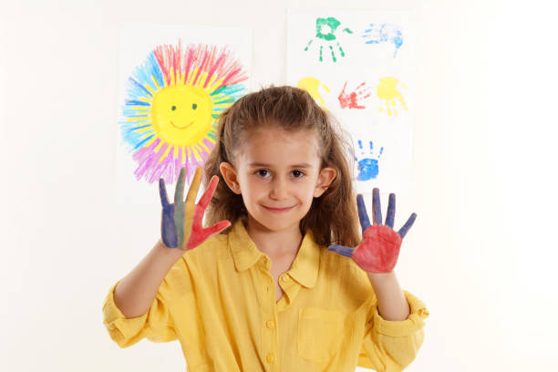 istock Girl showing colorful painted hands 1211030737