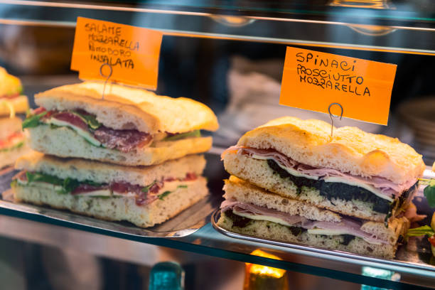 afficher le gros plan du pain avec le sandwich panini de mozzarella et de prosciutto pour le déjeuner dans le magasin de magasin à florence, marché d’italie - panini italien photos et images de collection