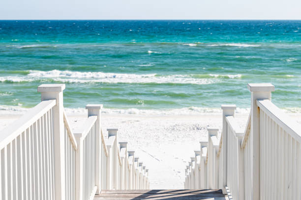 istock Seaside, Florida railing wooden stairway walkway steps architecture by beach ocean background view down during sunny day 1211031259