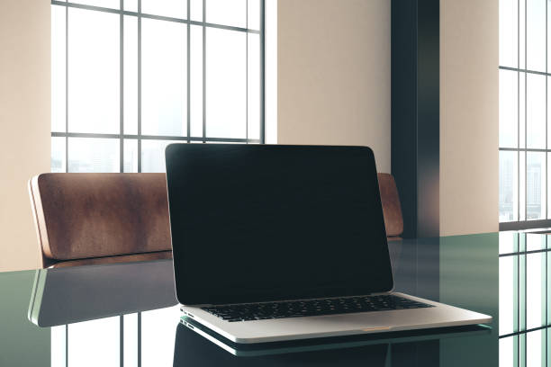 istock Blank laptop on glass office table 1211036369
