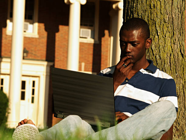 College Student on a Laptop a black college student on his laptop on campus. oxford ohio photos stock pictures, royalty-free photos & images