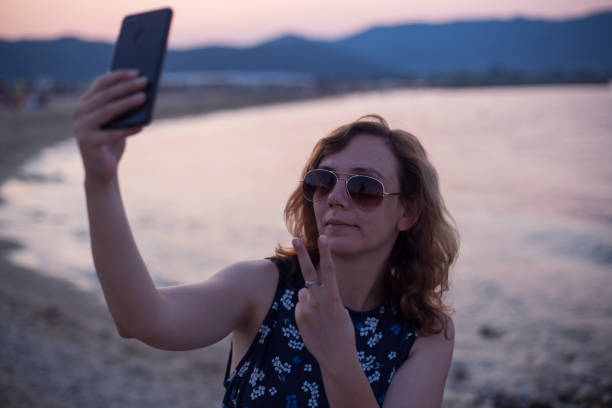 istock Tourist woman taking selfie on a beach 1211041199