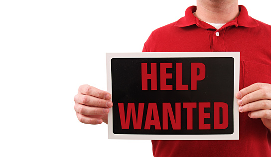 a man holding a help wanted isolated on white.
