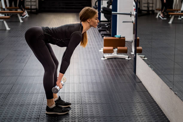 Beautiful woman performs Romanian deadlift in gym stock photo