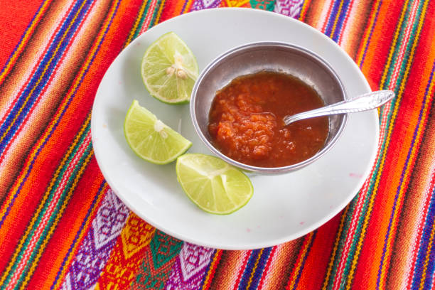 Chili sauce served on a metal bowl with lime slices