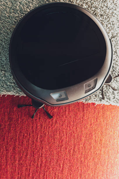 istock Robotic vacuum cleaner on carpet - technology housework. 1211046269