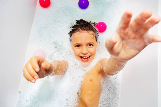 istock Fun in bathtub boy swim with soap and reach hand 1211046556