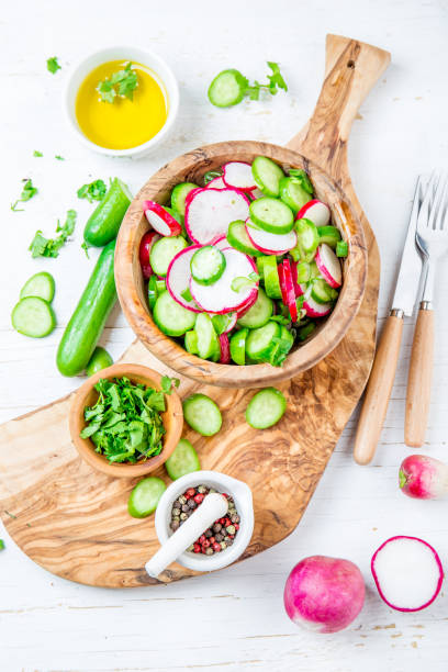 istock Fresh radish cucumber salad, white background. Top view 1211046888