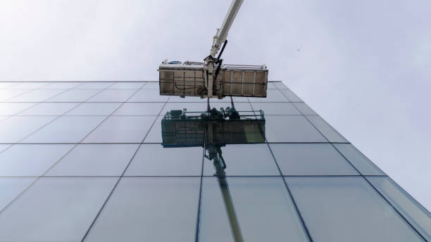 istock High-altitude work. Team of blue-collar workers working on the office building glass facade using the lifting platform. 1211047006