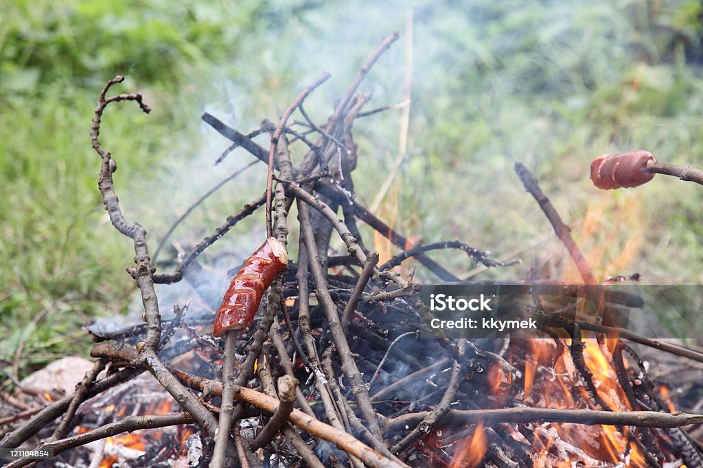 Arrostire salsicce su Fuoco di accampamento - Foto stock royalty-free di Alla griglia