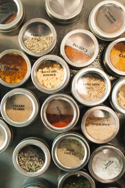 Stainless steel jars with spices Variety of mixed prices in magnetic stainless teel jars on the side of the fridge spice rack stock pictures, royalty-free photos & images