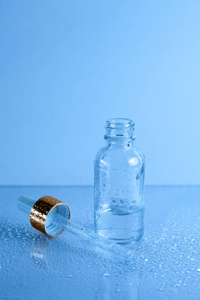 istock Classic blue background with glass bottle and medicine dropper 1211052125